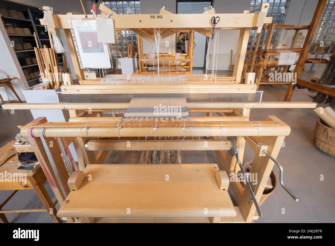 La filettatura viene tessuta utilizzando il telaio su una vecchia macchina in legno Foto Stock