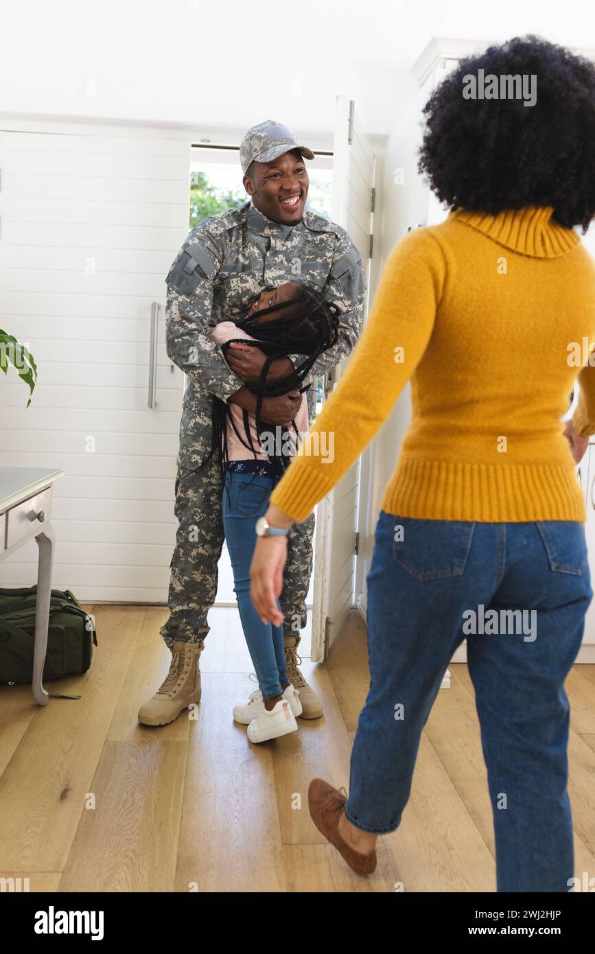 Felice famiglia afro-americana che abbraccia e accoglie a casa, spazio fotocopie Foto Stock