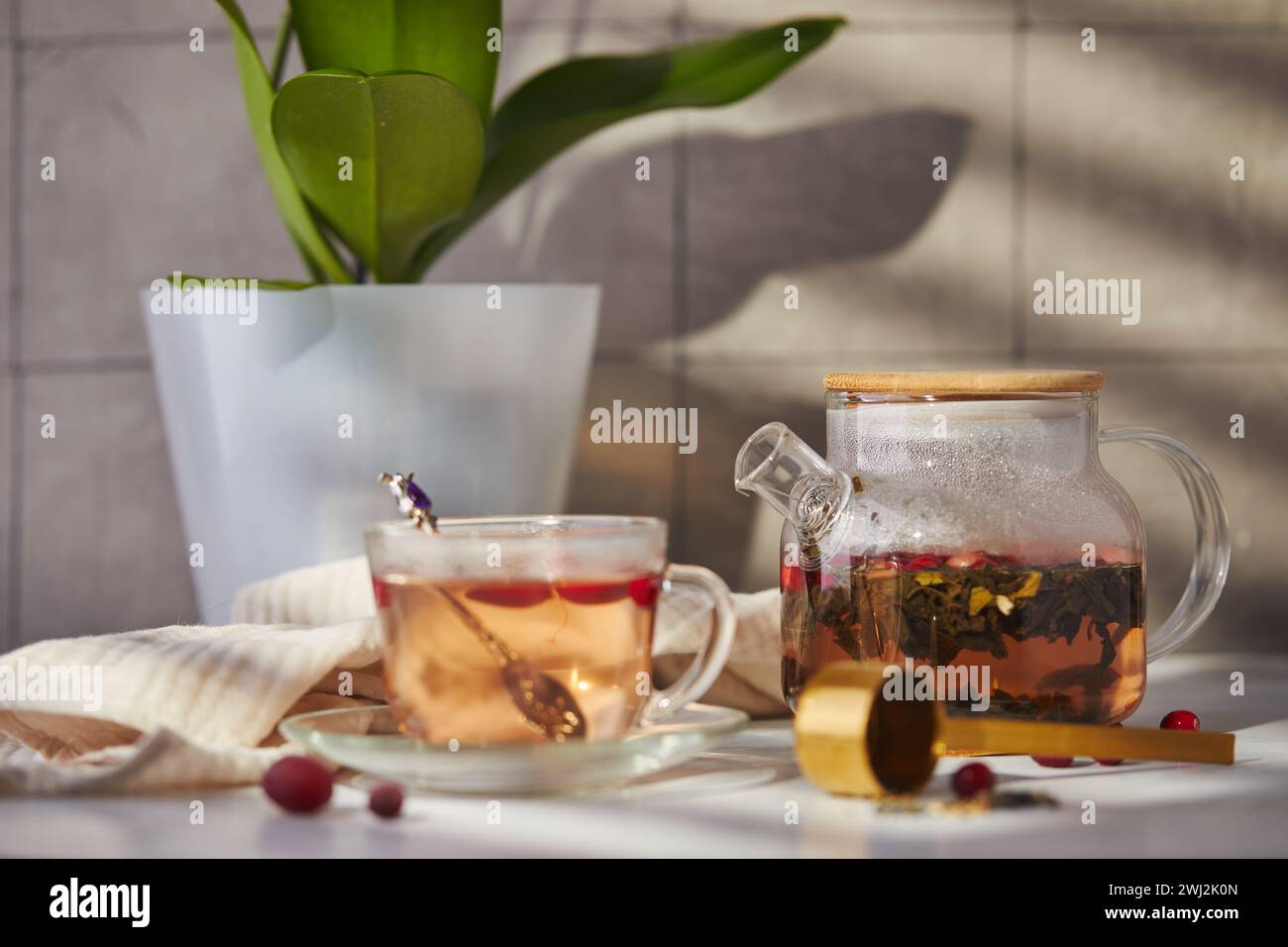 Frutta e tè alle bacche. Teiera in vetro e tazza sul tavolo Foto Stock
