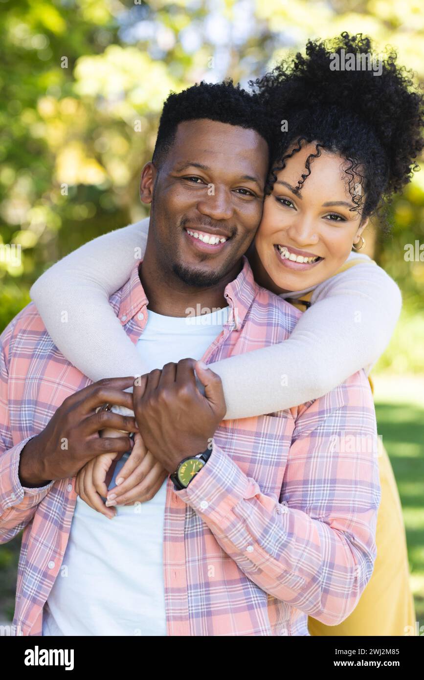 Felice coppia afroamericana che abbraccia nel giardino soleggiato, spazio fotocopie Foto Stock