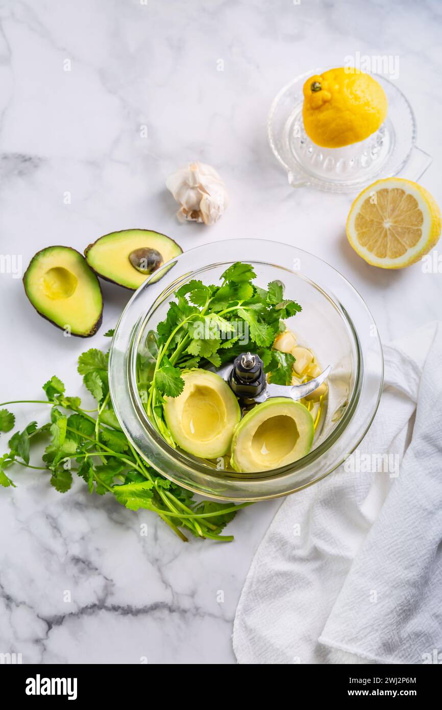 Preparazione di condimenti fatti in casa con avocado o immersione nel robot da cucina. Foto Stock