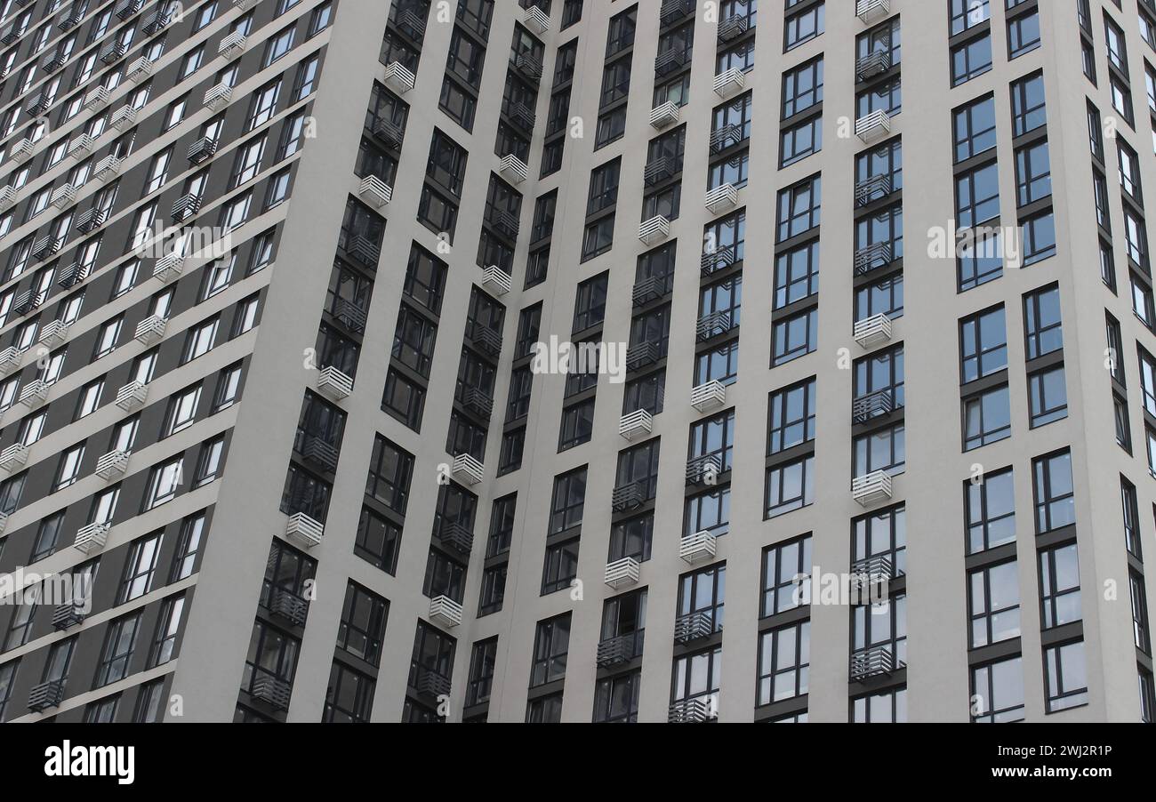 Facciata di un alto e moderno edificio con appartamenti economici e piccoli balconi Foto Stock