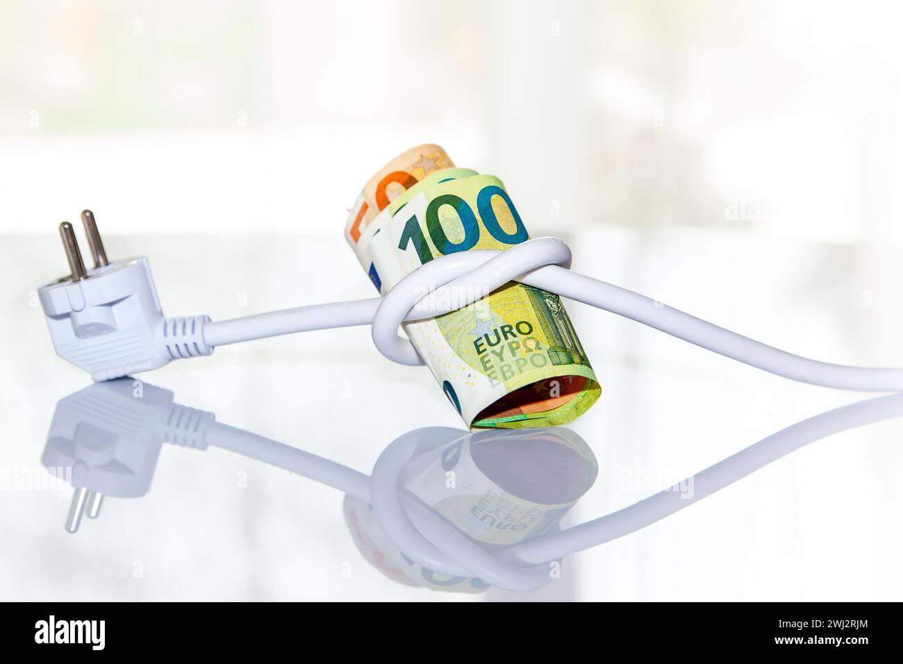 Rotolo di banconote in euro legato con una spina elettrica. su sfondo chiaro. Concetto di salvataggio degli eletti Foto Stock