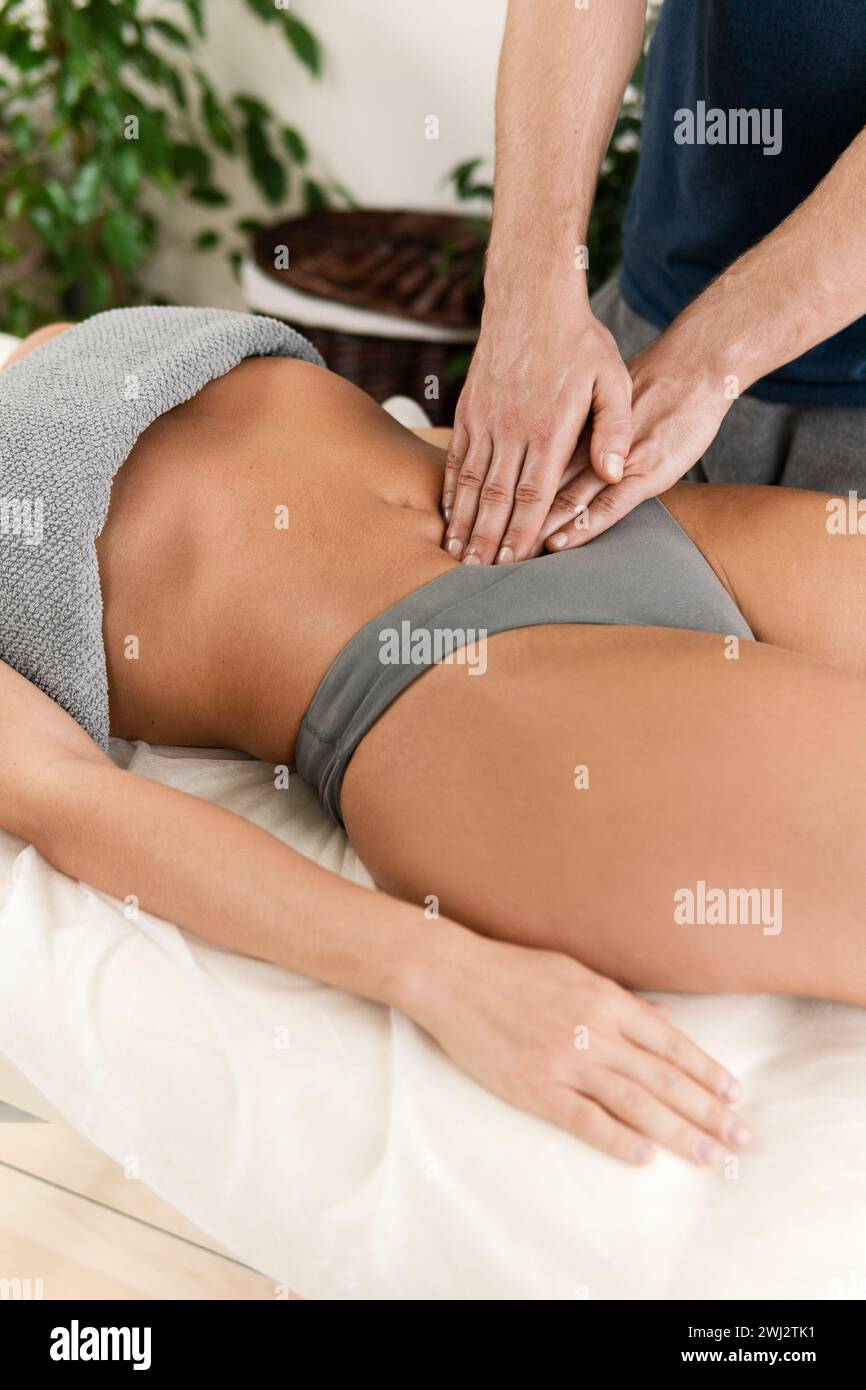 Primo piano delle mani del massaggiatore durante il massaggio allo stomaco Foto Stock