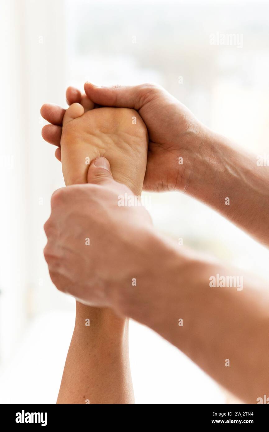 Uomo massaggiatore durante il massaggio ai piedi femminile Foto Stock