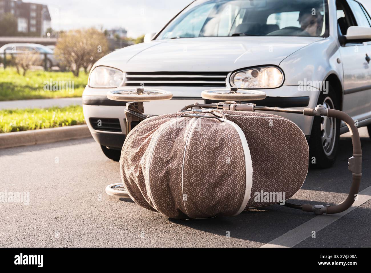 Il veicolo colpisce la carrozzina per bambini sulla strada. Gli incidenti automobilistici sono la causa dei messaggi di testo e della guida Foto Stock