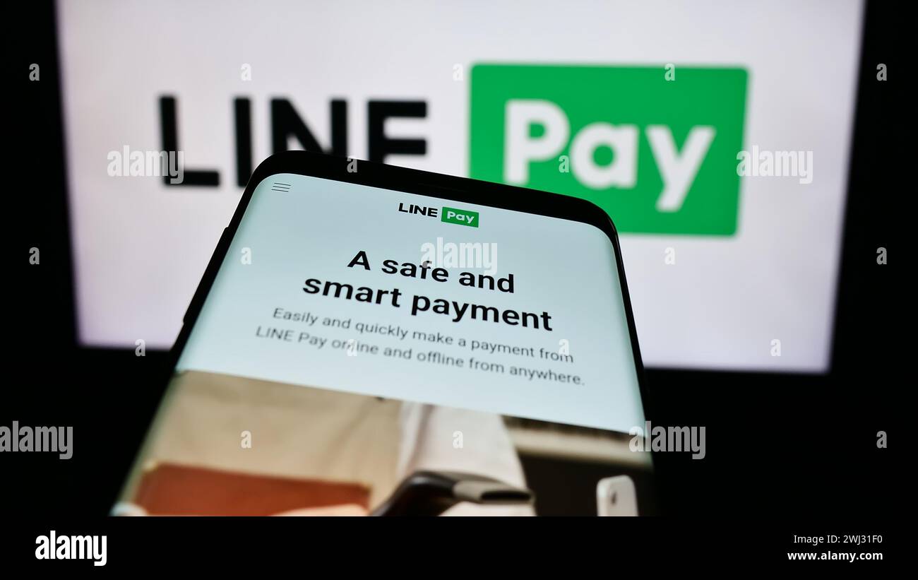 Smartphone con sito web della società thailandese DI pagamento LINE pay davanti al logo aziendale. Mettere a fuoco in alto a sinistra sul display del telefono. Foto Stock