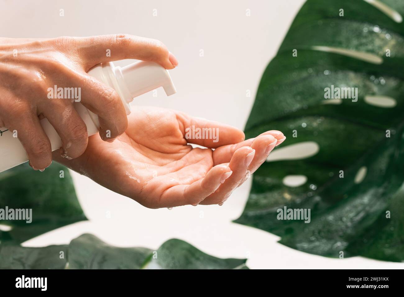 La donna sta applicando schiuma detergente sulla mano Foto Stock