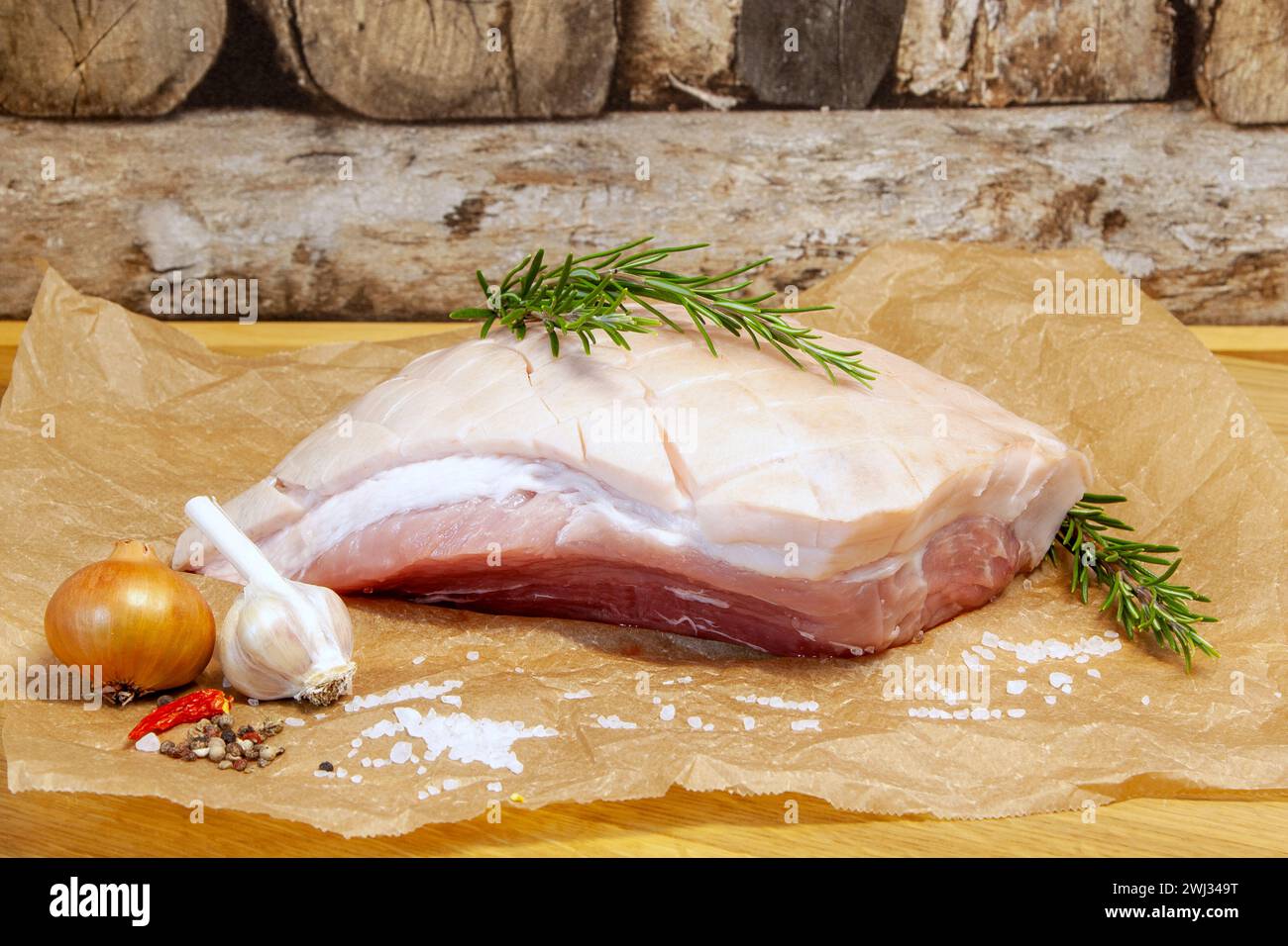 Pancetta di maiale cruda con sale marino, cipolla, aglio ed erbe aromatiche, rosmarino. Maiale arrosto salato, crosta bavarese Foto Stock