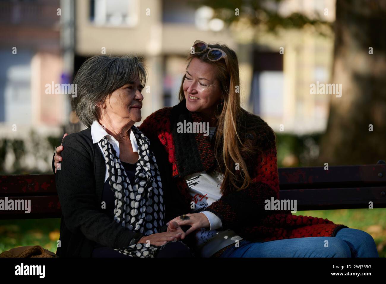 Anziana donna carina con Alzheimer molto felice e sorridente quando la figlia maggiore abbraccia e si prende cura di lei Foto Stock