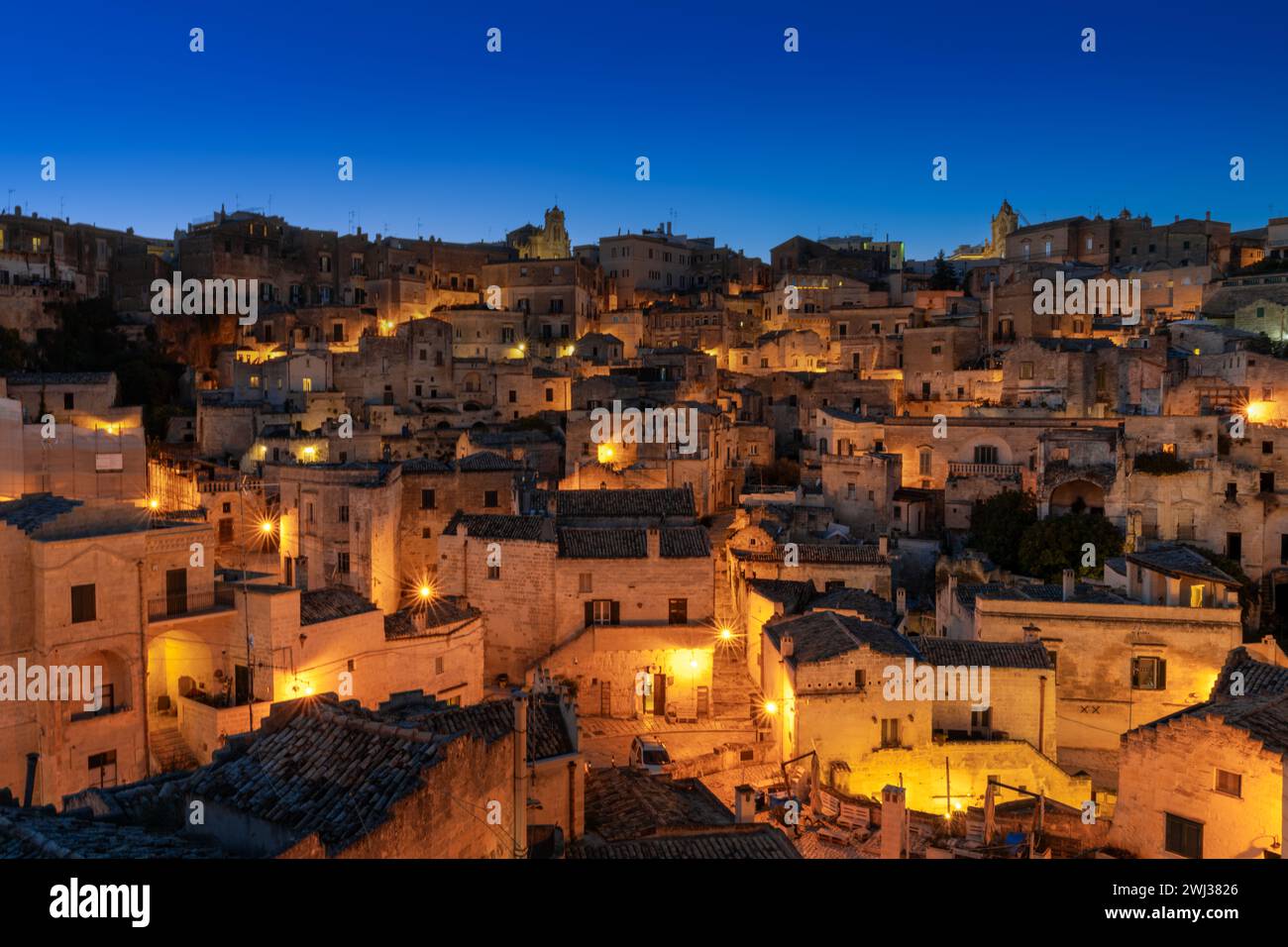 Vista della città vecchia di Matera dopo il tramonto con le luci accese Foto Stock