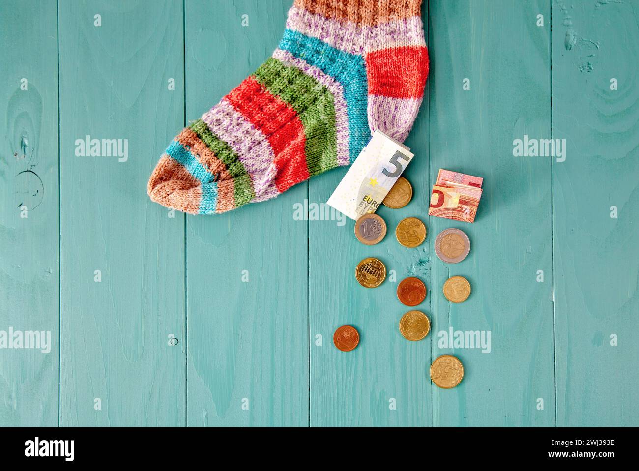 Salvataggio calzino. Le monete fuoriescono da Wool Sock. soldi in euro nel calzino. risparmi pensionistici e nascondiglio Foto Stock