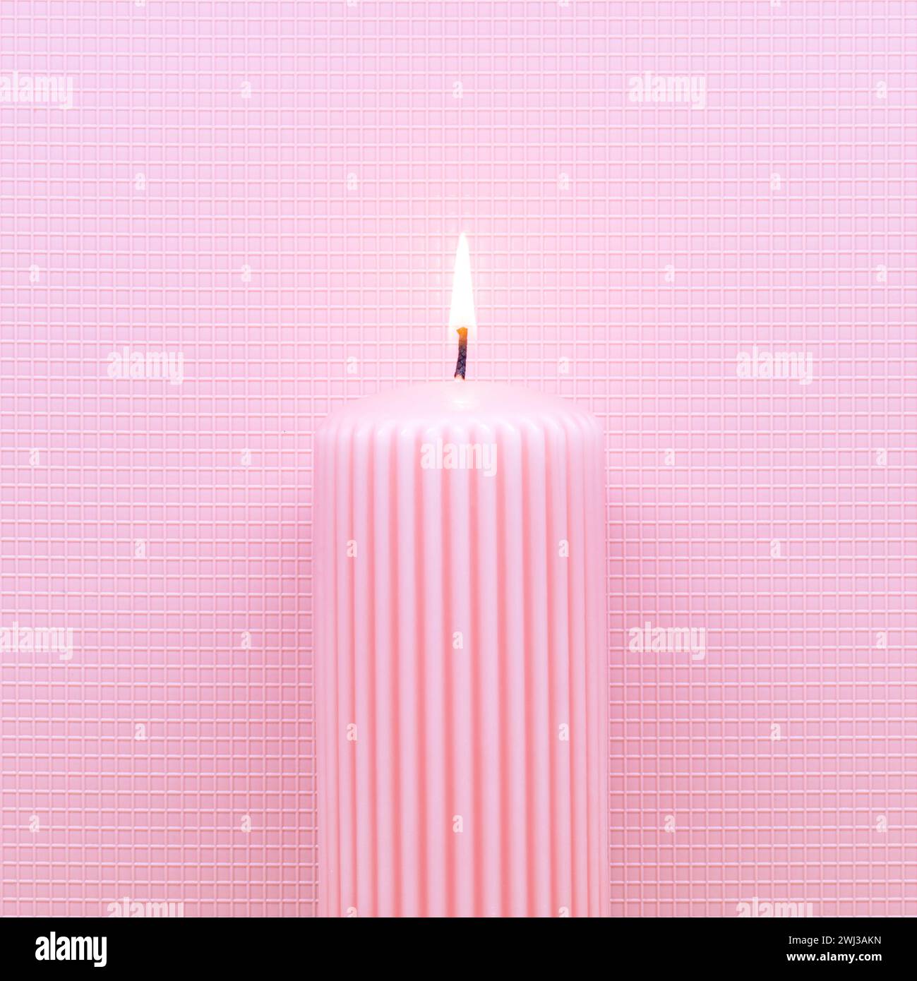 Candela che brucia astratta su sfondo rosa. Piatto minimo a tema Natale o compleanno. Anno nuovo Foto Stock