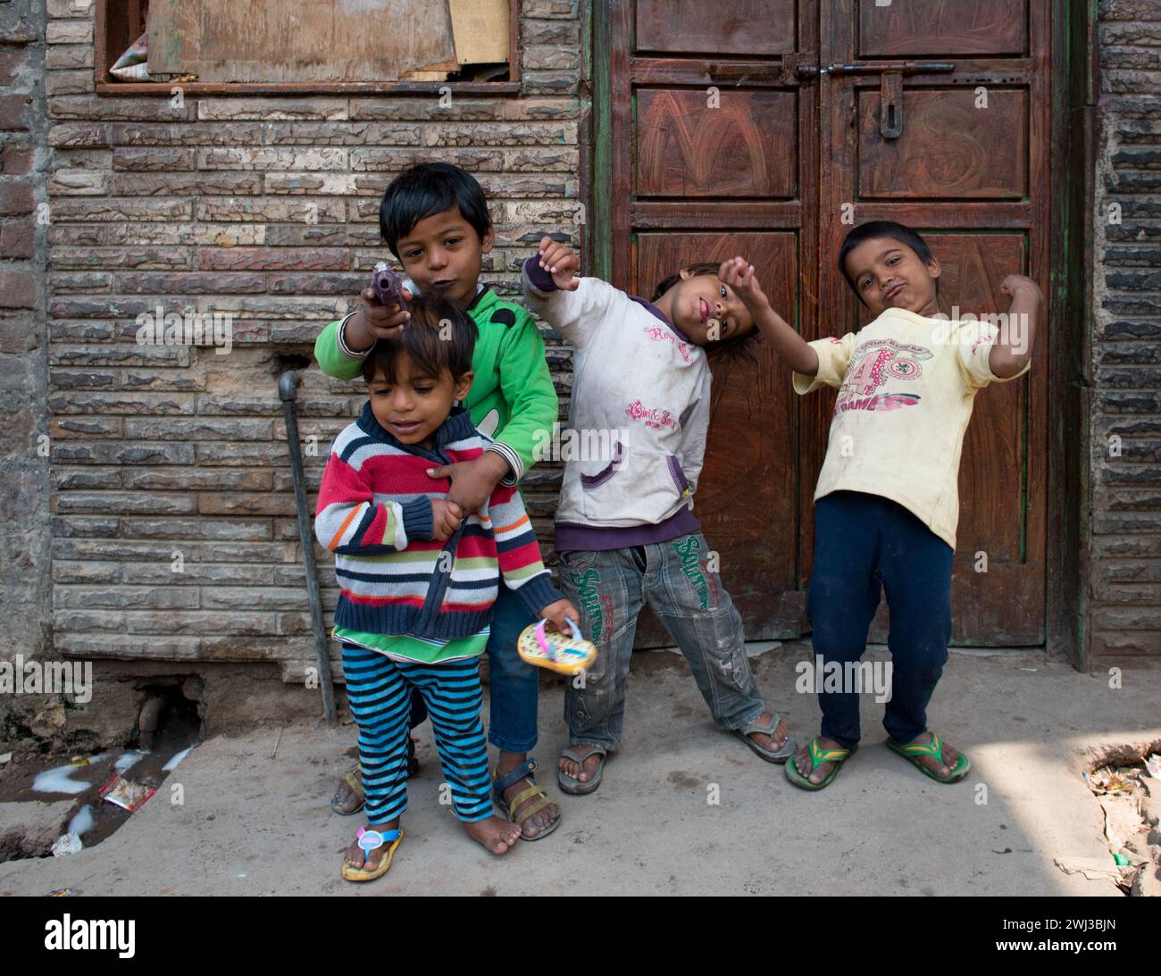 I bambini indiani asiatici giocano indossando abiti colorati giocano felici all'aperto. Bambini attivi Foto Stock