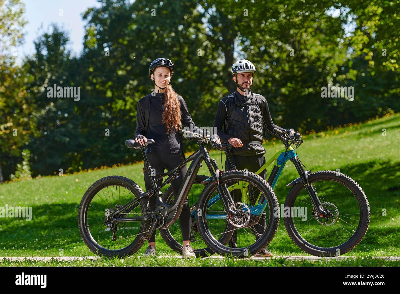Una dolce coppia, dotata di biciclette e impegnata a coordinare il proprio viaggio, controlla il proprio GPS mobile e guarda mentre PL Foto Stock
