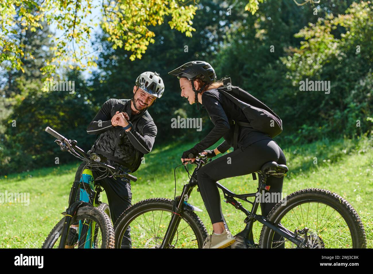 Una dolce coppia, dotata di biciclette e impegnata a coordinare il proprio viaggio, controlla il proprio GPS mobile e guarda mentre PL Foto Stock