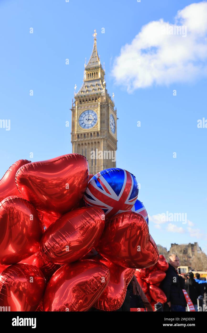 Palloncini Red, Valentine Heart in vendita sul Westminster Bridge, con il Big Ben alle spalle, a Londra, Regno Unito Foto Stock