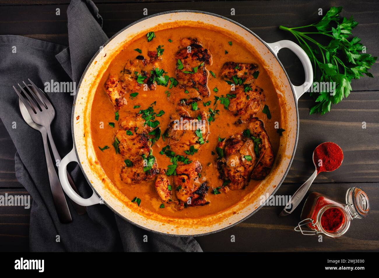 Paprikash di pollo ungherese fatto in casa in una pentola grande: Cosce di pollo cotte a fuoco lento in una ricca salsa di paprika dolce e panna acida Foto Stock