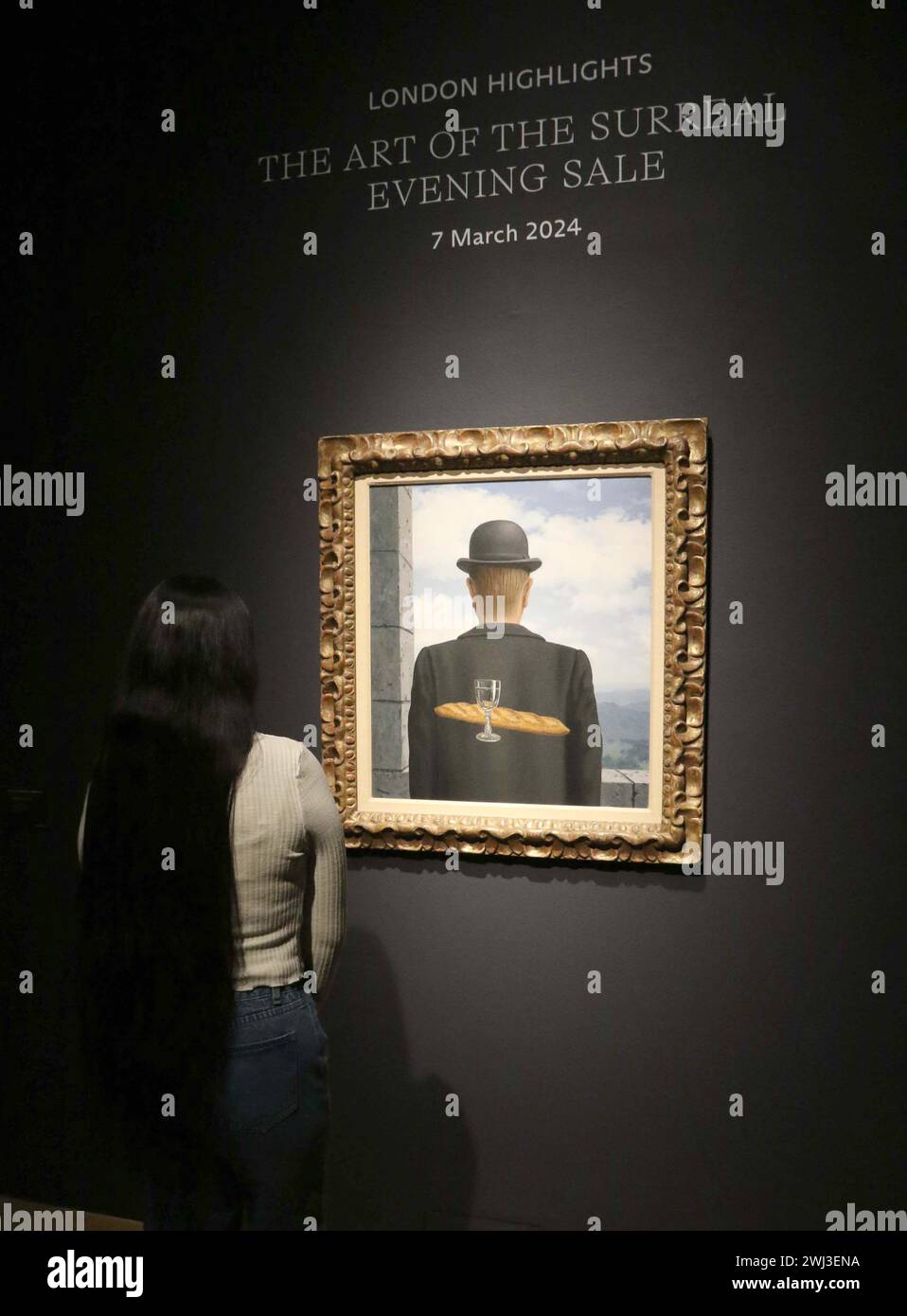 New York, New York, Stati Uniti. 12 febbraio 2024. Una donna vede ''˜l'ami intime' (l'amico intimo) dell'artista René Magritte, dipinto tra gennaio e febbraio 1958, visto in mostra al Christie's Rockefeller Center, come parte del London Highlights ''˜The Art of the Surreal Evening sale'. L'alta stima per cui si prevede che il dipinto venderà è di 50 milioni di dollari - 63 milioni di dollari. (Credit Image: © Nancy Kaszerman/ZUMA Press Wire) SOLO PER USO EDITORIALE! Non per USO commerciale! Foto Stock