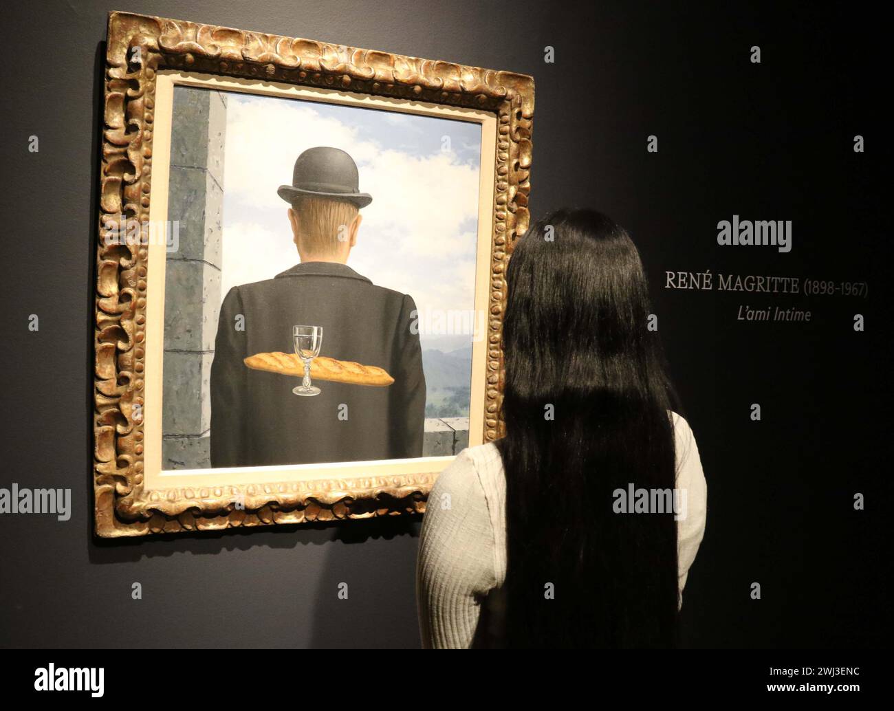 New York, New York, Stati Uniti. 12 febbraio 2024. Una donna vede ''˜l'ami intime' (l'amico intimo) dell'artista René Magritte, dipinto tra gennaio e febbraio 1958, visto in mostra al Christie's Rockefeller Center, come parte del London Highlights ''˜The Art of the Surreal Evening sale'. L'alta stima per cui si prevede che il dipinto venderà è di 50 milioni di dollari - 63 milioni di dollari. (Credit Image: © Nancy Kaszerman/ZUMA Press Wire) SOLO PER USO EDITORIALE! Non per USO commerciale! Foto Stock