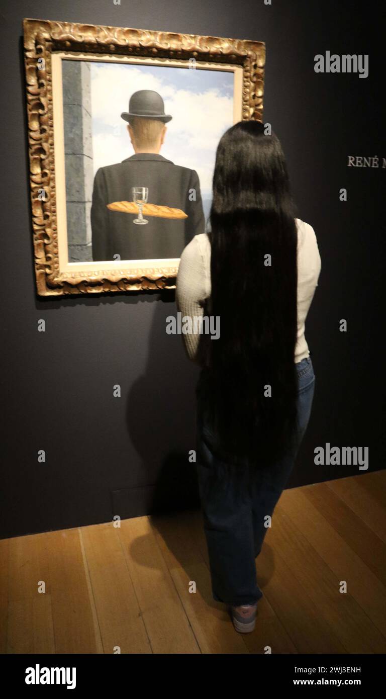 New York, New York, Stati Uniti. 12 febbraio 2024. Una donna vede ''˜l'ami intime' (l'amico intimo) dell'artista René Magritte, dipinto tra gennaio e febbraio 1958, visto in mostra al Christie's Rockefeller Center, come parte del London Highlights ''˜The Art of the Surreal Evening sale'. L'alta stima per cui si prevede che il dipinto venderà è di 50 milioni di dollari - 63 milioni di dollari. (Credit Image: © Nancy Kaszerman/ZUMA Press Wire) SOLO PER USO EDITORIALE! Non per USO commerciale! Foto Stock