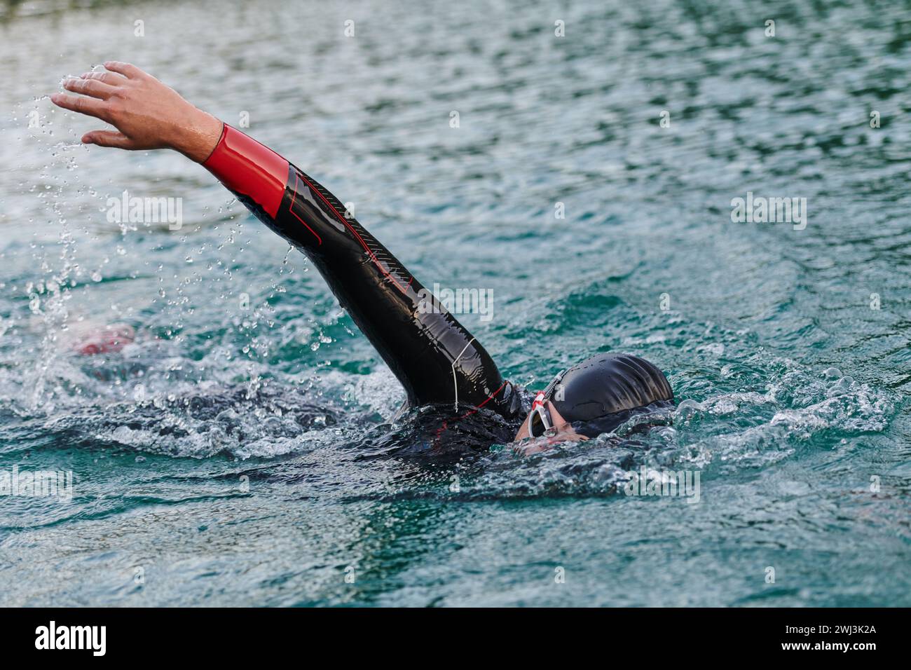 Un triatleta professionista si allena con una dedizione costante per una prossima gara in un lago, emanando un senso di atletica Foto Stock