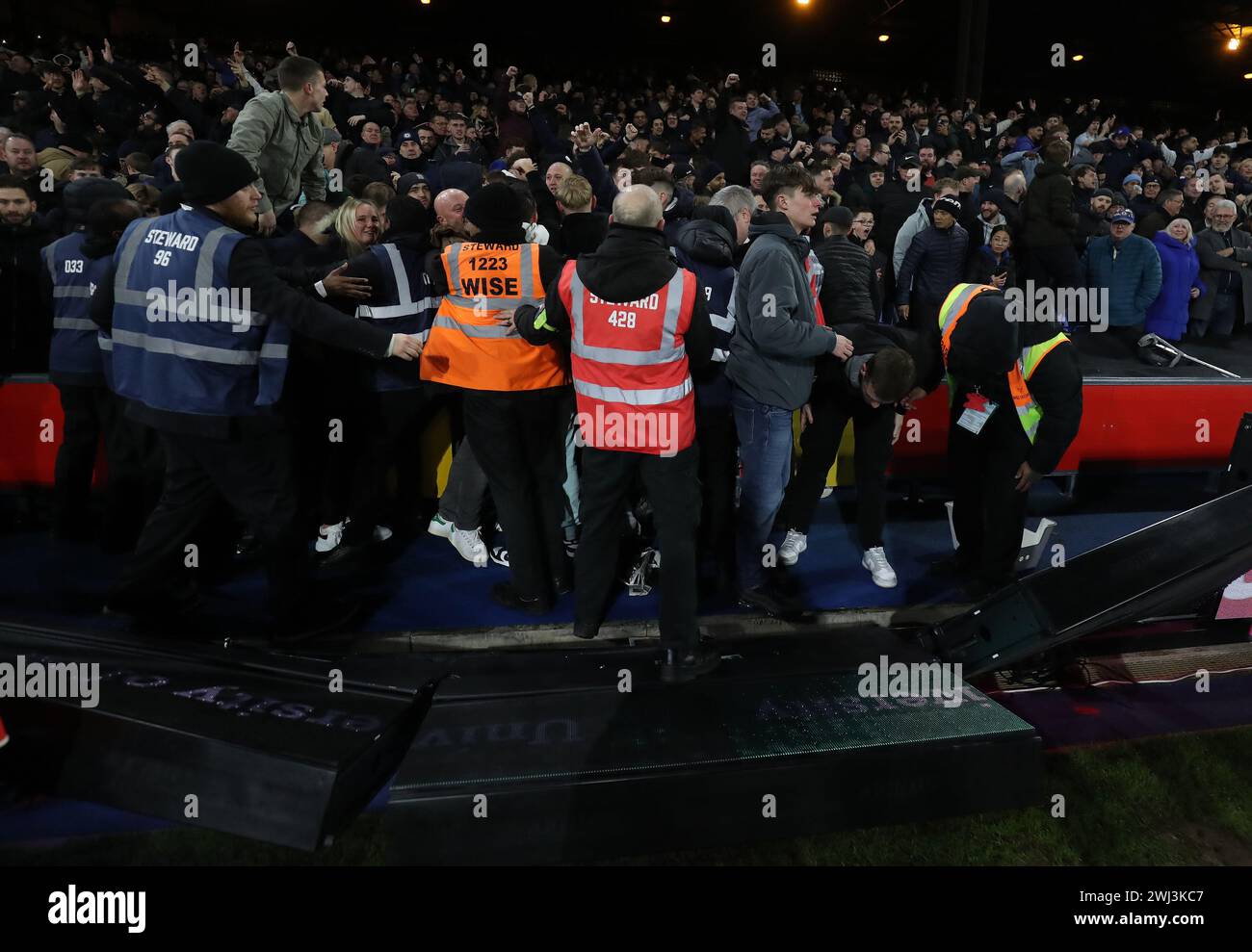 Londra, Regno Unito. 12 febbraio 2024. La sicurezza tiene i tifosi fuori dal campo dopo che i tabelloni pubblicitari sono stati respinti in seguito ai festeggiamenti dopo che Conor Gallagher del Chelsea ha ottenuto 2-1 punti durante la partita di Premier League al Selhurst Park di Londra. Il credito per immagini dovrebbe essere: Paul Terry/Sportimage Credit: Sportimage Ltd/Alamy Live News Foto Stock