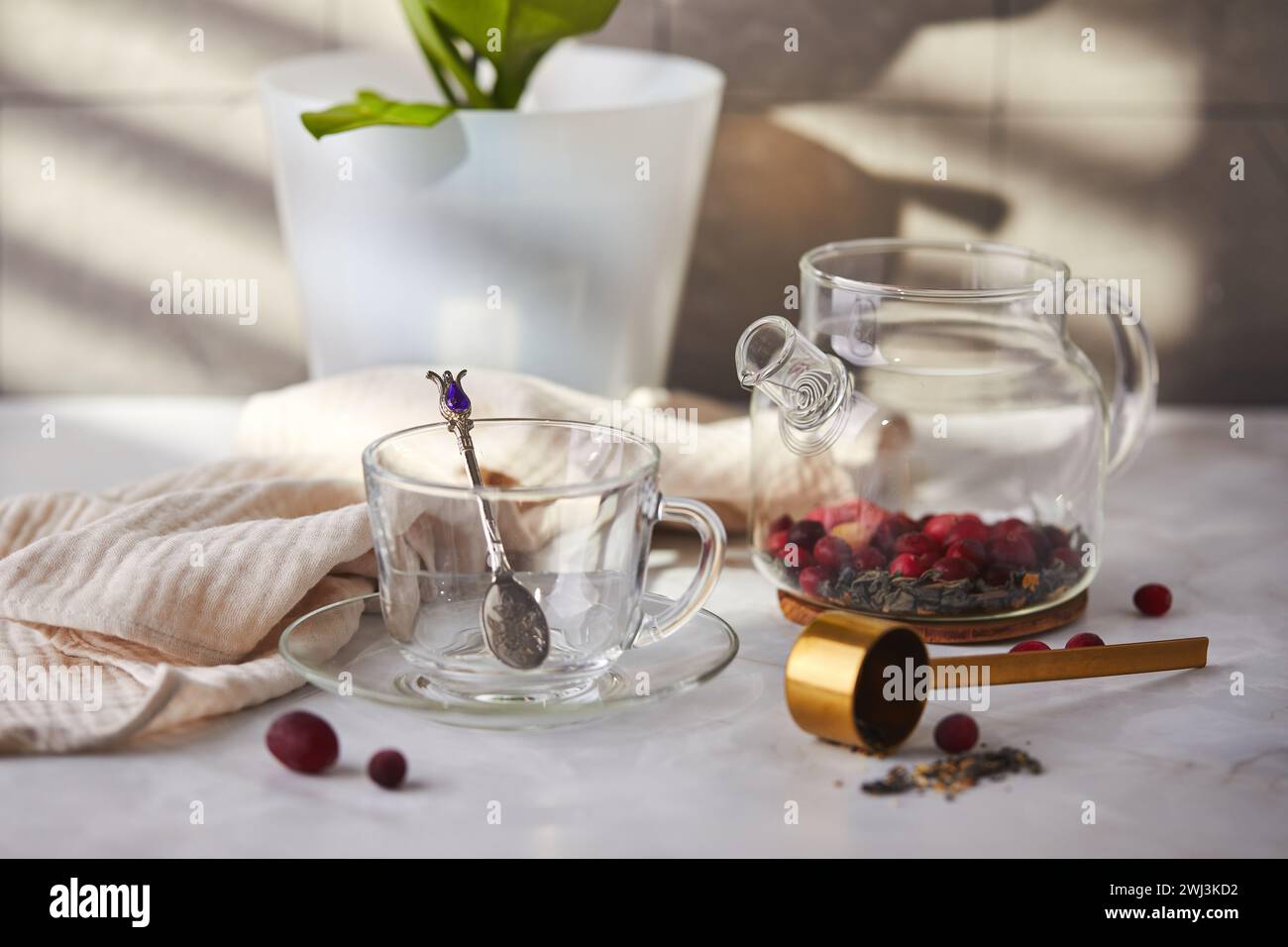 Frutta e tè alle bacche. Preparazione. Svuotare la teiera in vetro e la tazza sul tavolo Foto Stock