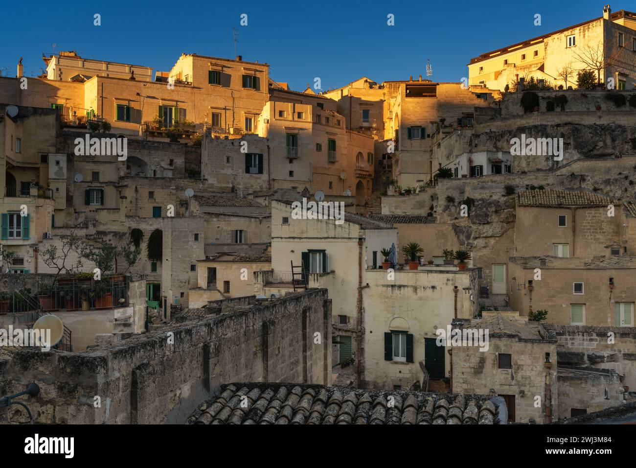 Vista ravvicinata del centro storico di Matera con le case in pietra degli ultimi raggi del sole Foto Stock