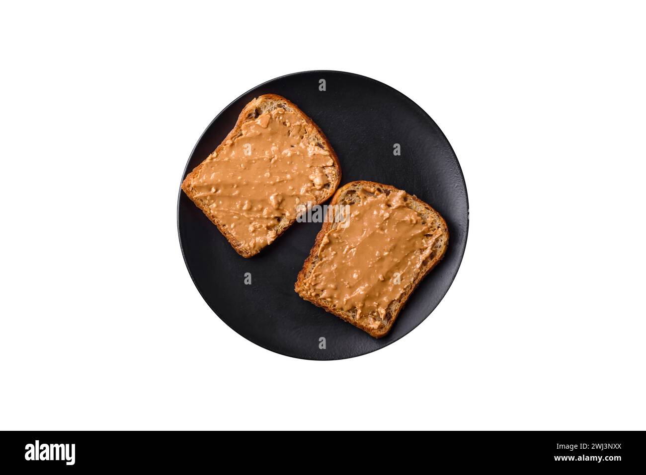 Sandwich nutriente composto da pane e burro di arachidi su un piatto di ceramica nera Foto Stock