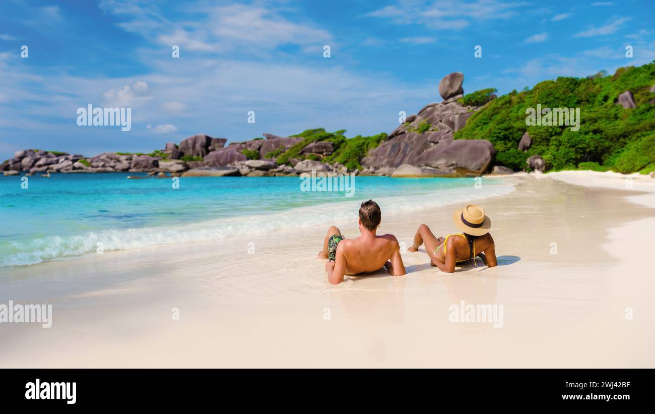 Donne asiatiche e uomini bianchi che si rilassano sulla spiaggia al sole alle Isole Similan in Thailandia Foto Stock