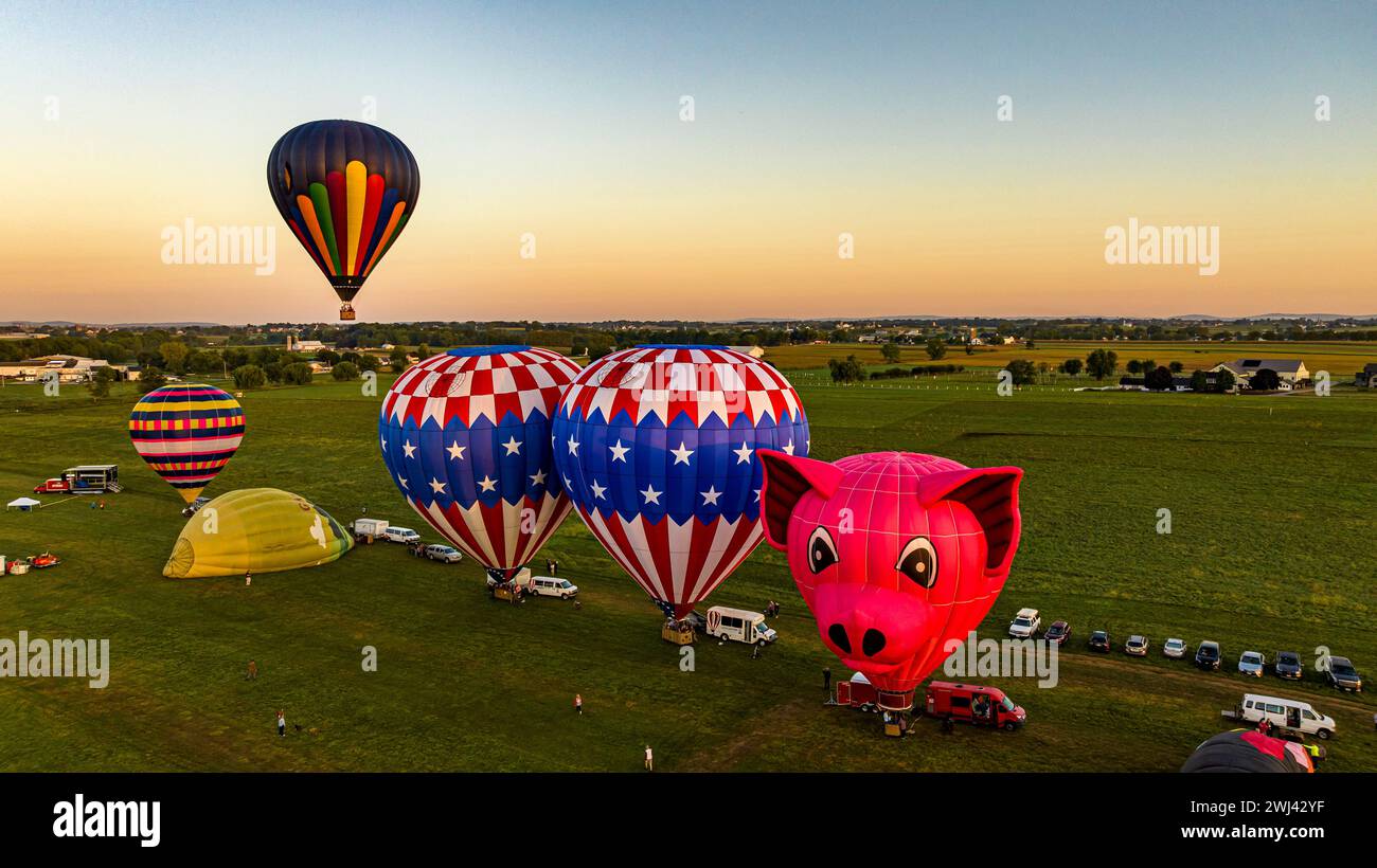 Vista aerea su due mongolfiere che partono, la mattina presto, da un campo in America rurale Foto Stock