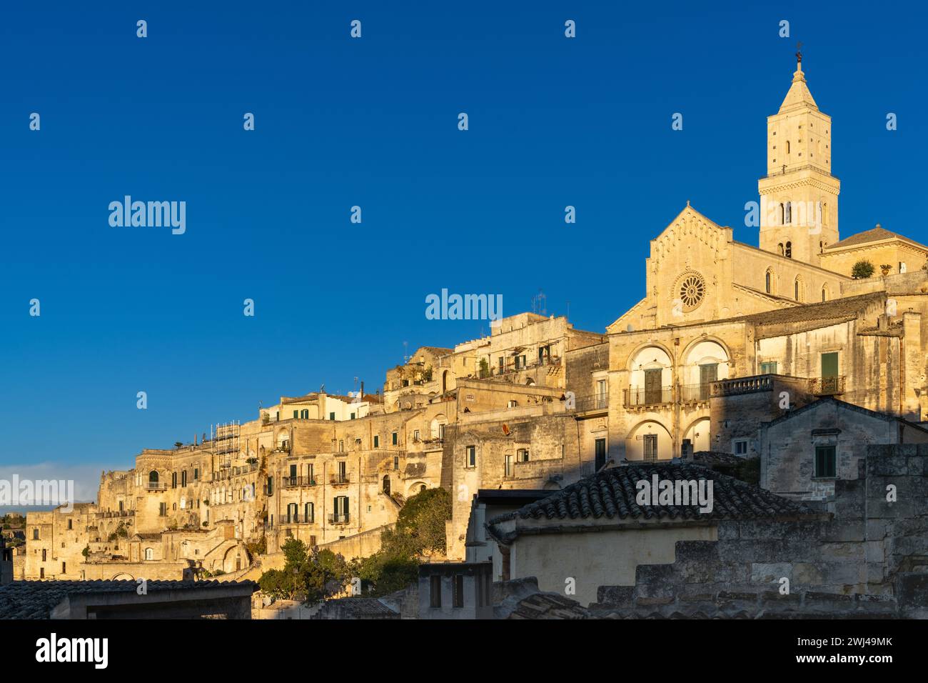 Vista della storica Cattedrale di Maratea e delle case in pietra dei Sassi di Matera nella calda luce dorata della sera Foto Stock