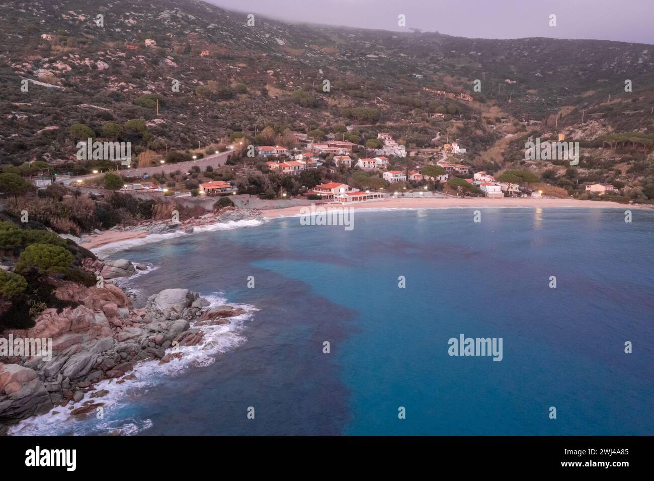 Vista droni della spiaggia di Cavoli sull'Isola d'Elba subito dopo il tramonto con un cielo viola nebbioso Foto Stock