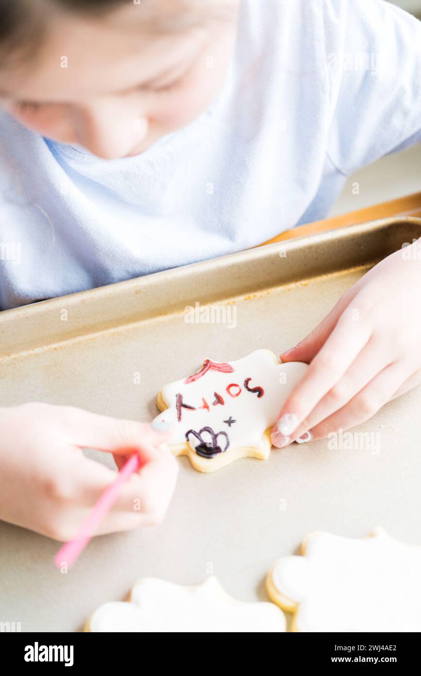 Little Girl parla "mi dispiace" su Iced Sugar Cookies Foto Stock