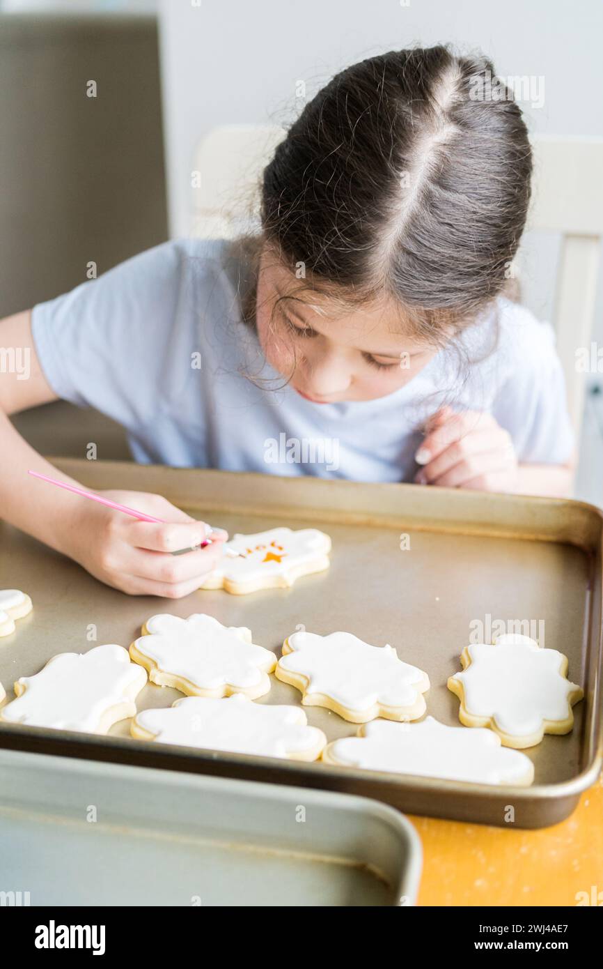 Little Girl parla "mi dispiace" su Iced Sugar Cookies Foto Stock