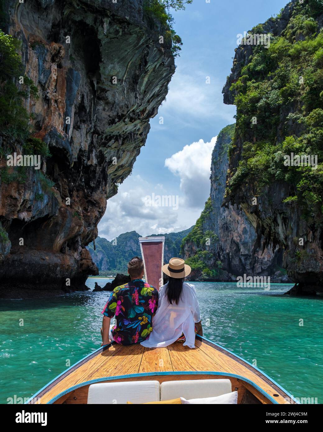 Donna asiatica e uomo europeo di mezza età in vacanza in Thailandia seduti di fronte a una barca a coda lunga Foto Stock