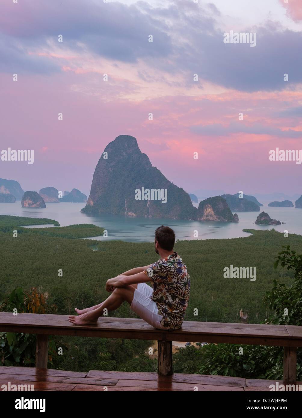 Un uomo che guarda l'alba al punto panoramico di Sametnangshe delle montagne nella baia di Phangnga in Thailandia Foto Stock