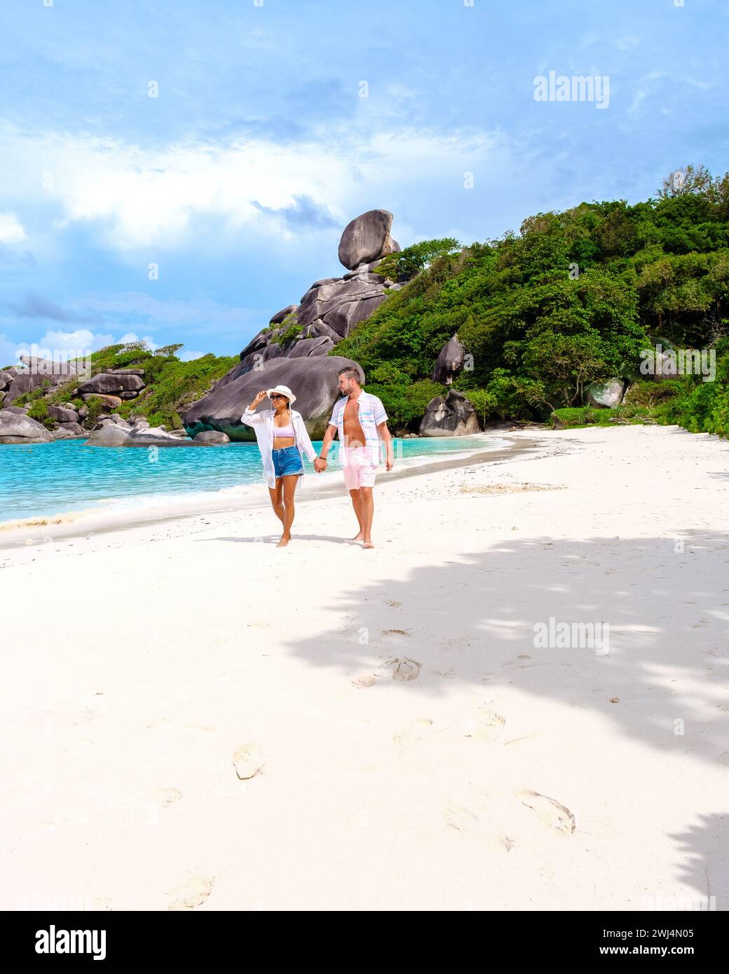 Donne asiatiche e uomini bianchi che si rilassano sulla spiaggia al sole alle Isole Similan in Thailandia Foto Stock