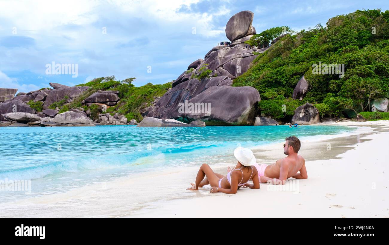 Donne asiatiche e uomini bianchi che si rilassano sulla spiaggia al sole alle Isole Similan in Thailandia Foto Stock