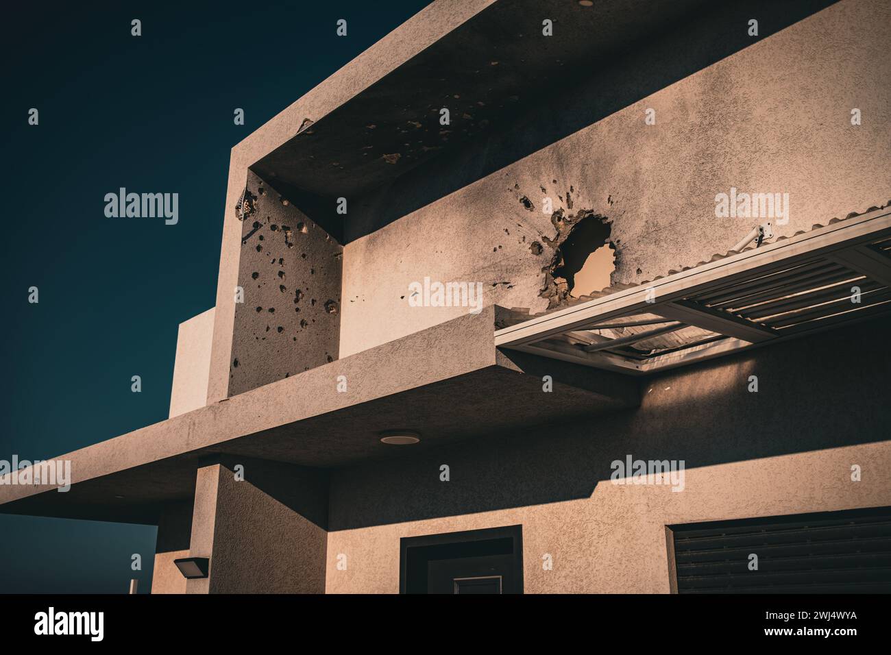 Fori proiettili in un muro di cemento sul lato dell'edificio Foto Stock
