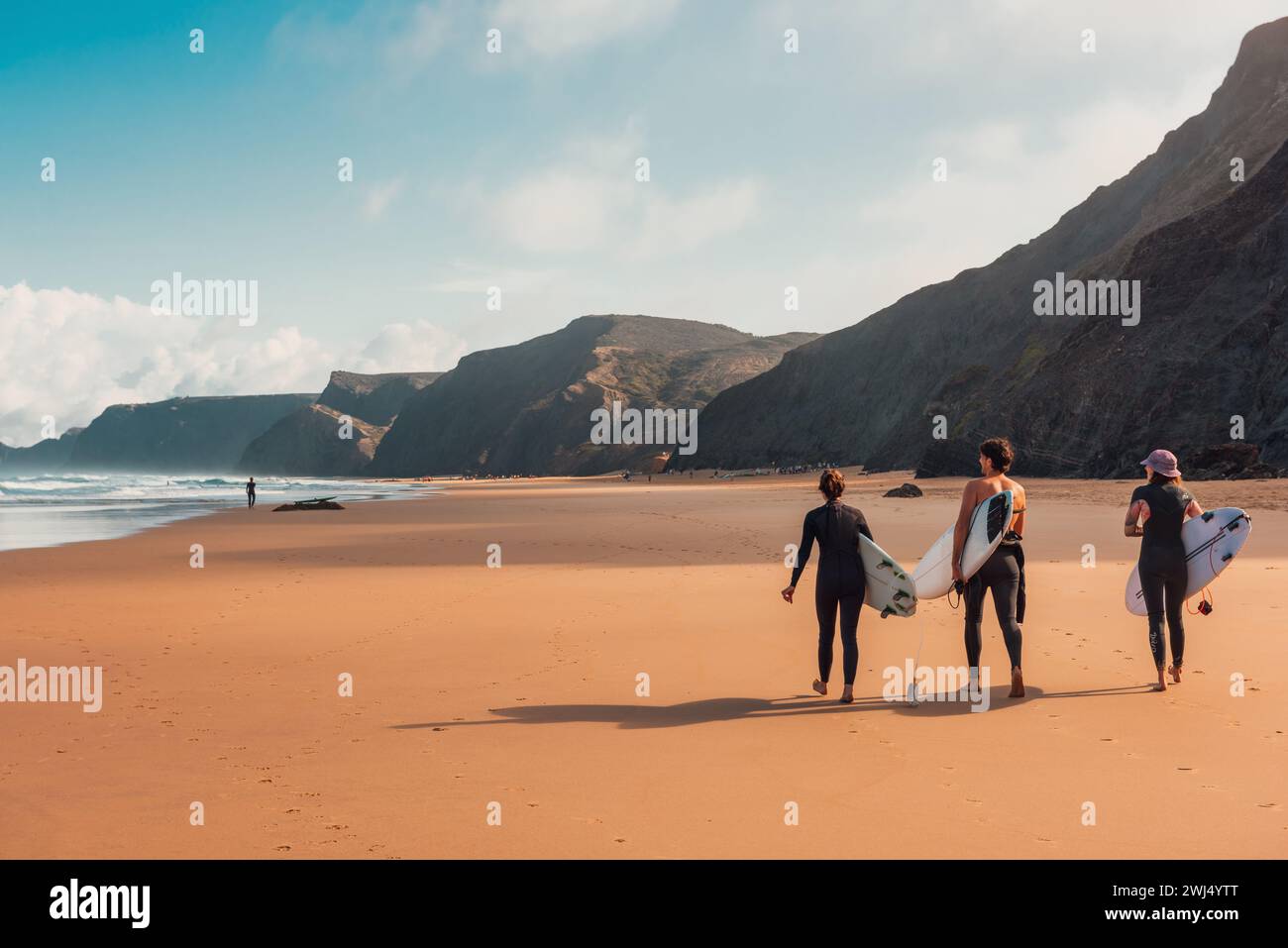 Giovani surfisti che camminano sulla spiaggia sabbiosa dell'Oceano Atlantico in Portogallo con tavole da surf Foto Stock