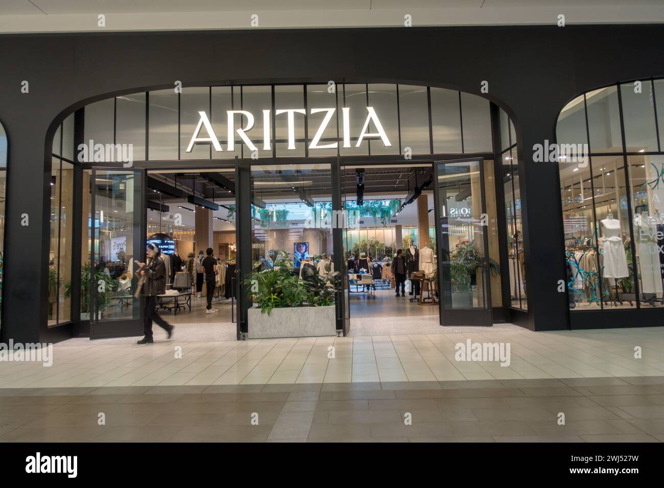 Burnaby, British Columbia, Canada - 12 febbraio 2024: Il moderno negozio nero e il logo di una boutique di moda Aritzia all'interno di Metropolis al centro commerciale Metrotown. Foto Stock