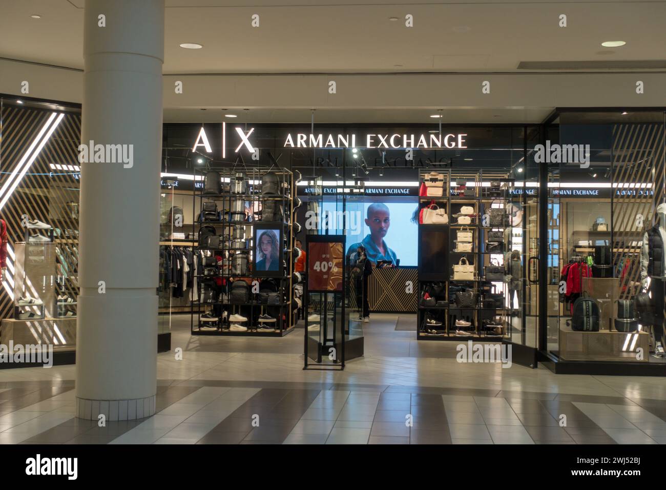 Burnaby, British Columbia, Canada - 12 febbraio 2024: Il moderno negozio di vetro di una boutique Armani Exchange al Metropolis presso il centro commerciale Metrotown durante il giorno. Foto Stock