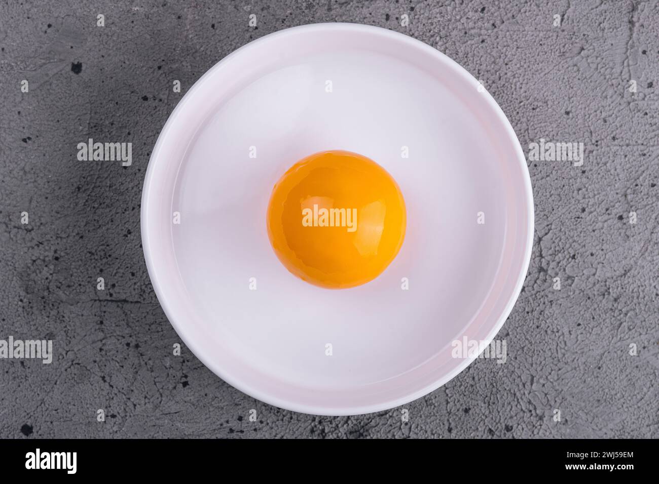 Tuorlo d'uovo nel recipiente separato per la cottura Foto Stock