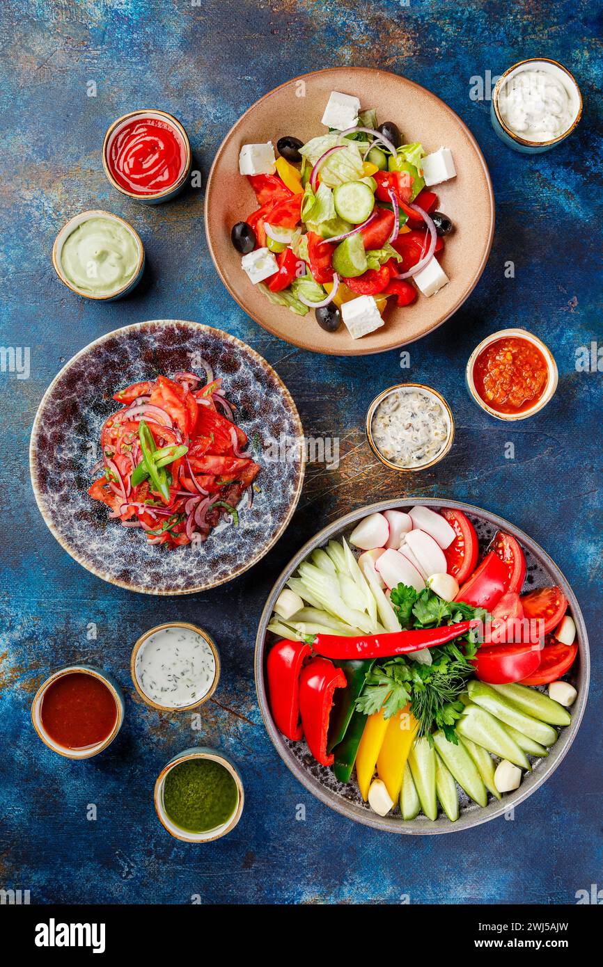 Piatto con verdure, peperoni, pomodori e verdure, piatti con insalate di verdure e vari tipi di salse Foto Stock