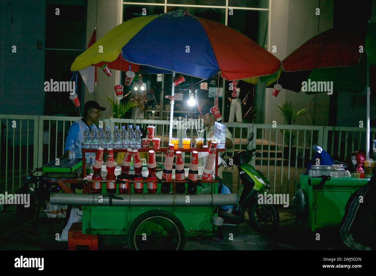 I venditori di bevande analcoliche e cibo vendono sul lato della strada di notte a Kediri, Giava Orientale, Indonesia. Foto Stock