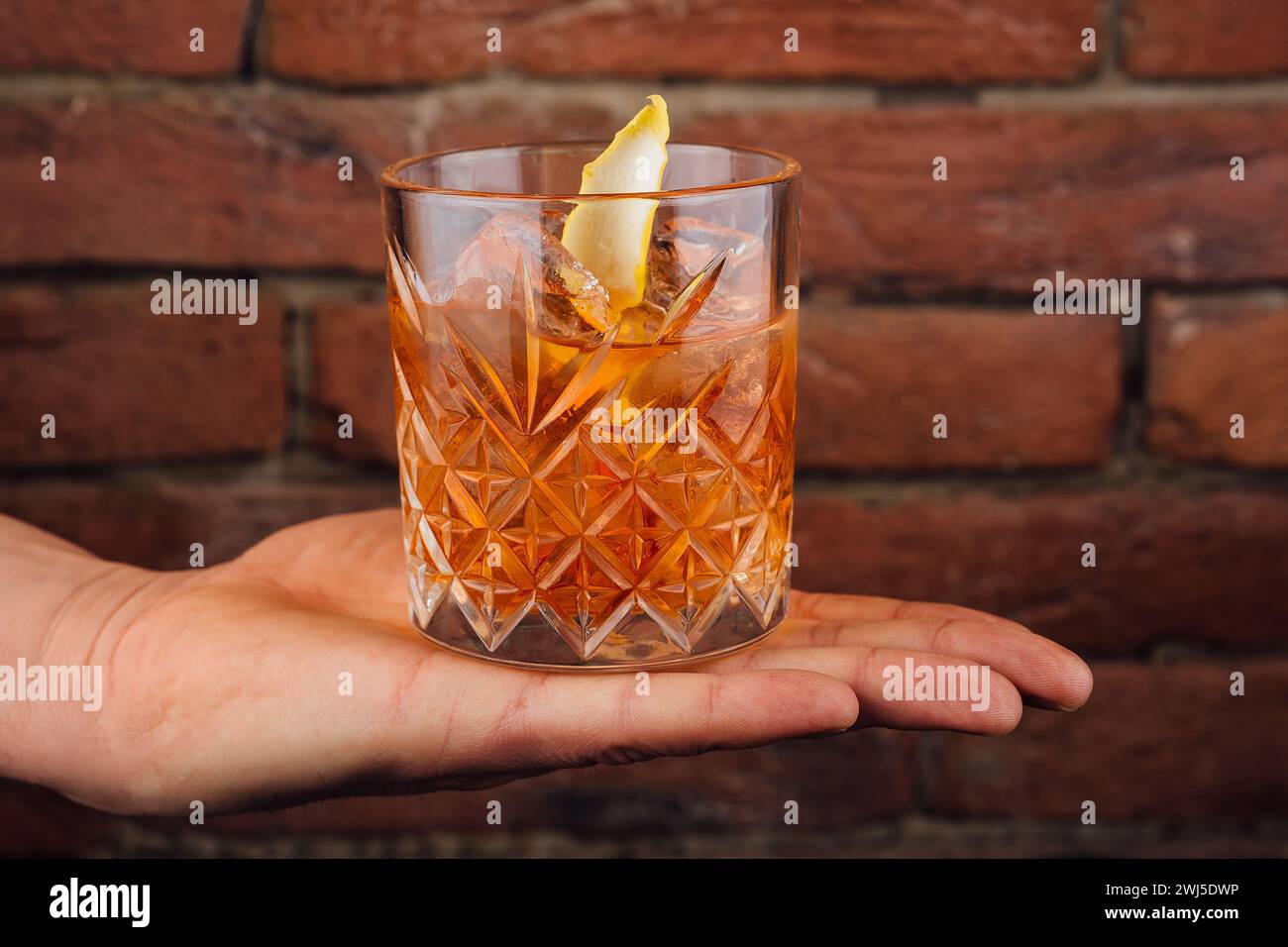 Il maschio tiene un bicchiere di whisky Foto Stock