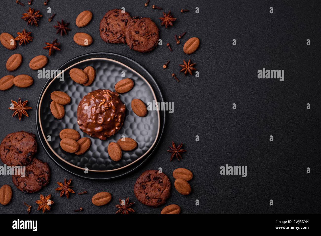 Deliziosa crostata di cioccolato con noci su un piatto di ceramica nera su fondo di cemento scuro Foto Stock