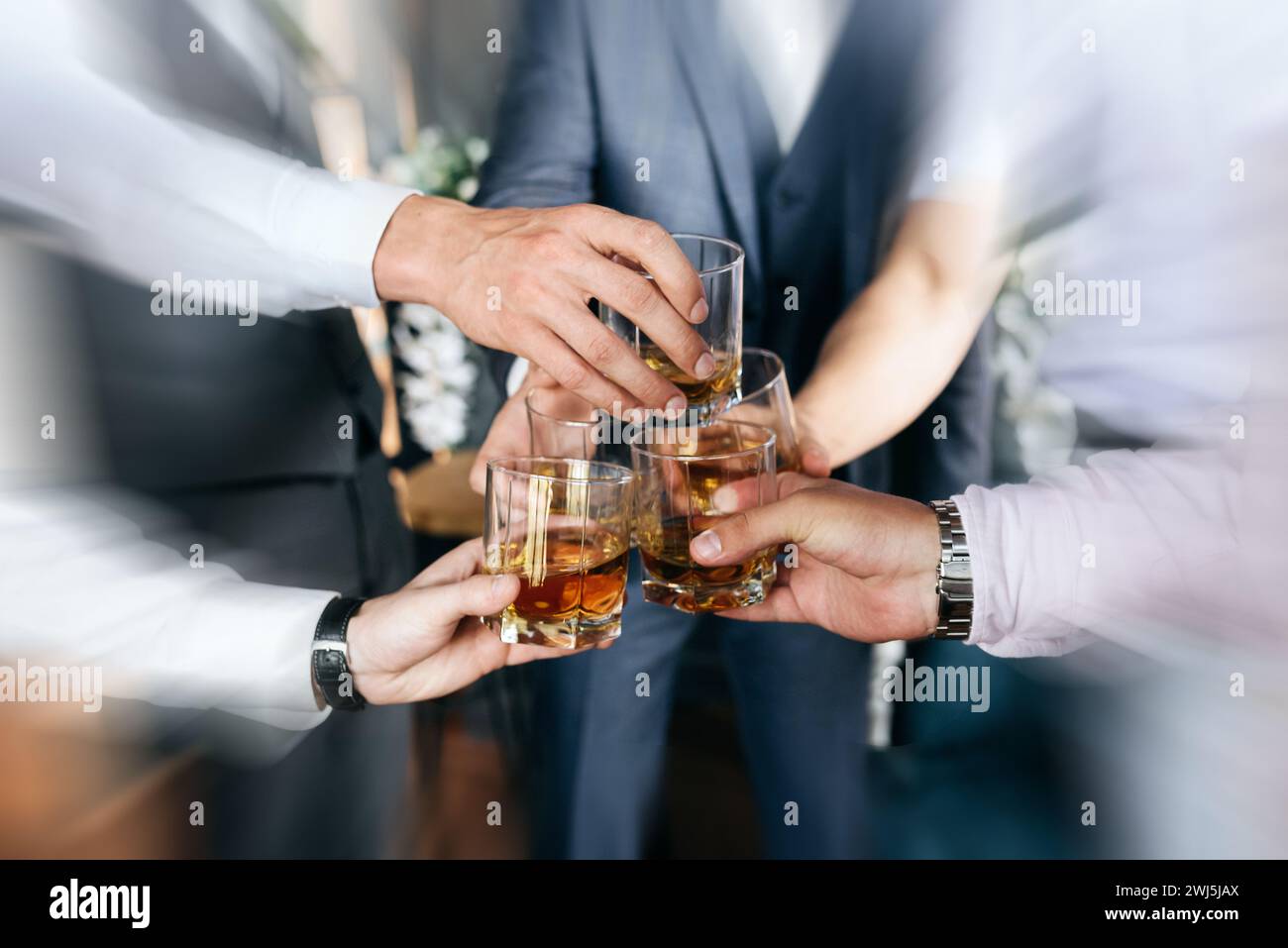 Vista ritagliata del gruppo di amici ragazzi con bicchieri di whiskey. Party di concetto, party di bachelor con effetto di sfocatura del movimento Foto Stock